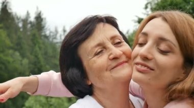Onun yetişkin kızı sarılma ve kameraya bakarak ile gülümseyen mutlu kafkas kıdemli anne Açık yakın portre. Yetişkin kızı anne, anneler günü öper