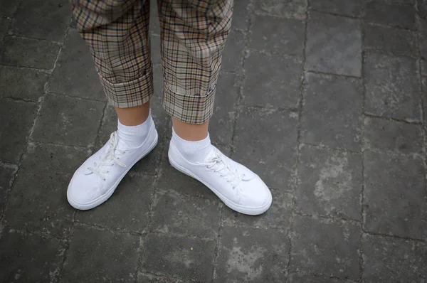 White sneaker shoes standing on the street. Hipster or casual concept