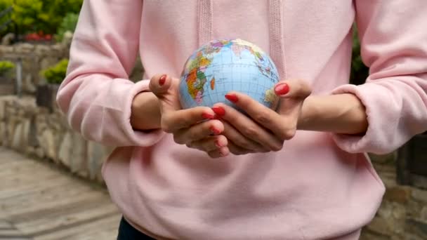 Vrouwelijke handen met rode manicure geven een kleine Globe met geograficale namen in Oekraïense Cyrillische letters op het. Human Responsibility concept — Stockvideo