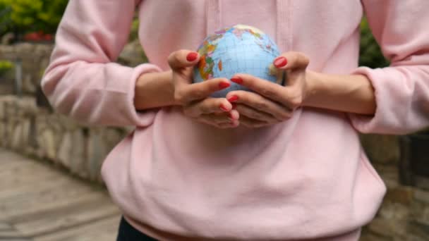 Manos femeninas con manicura roja dando un pequeño globo con nombres geográficos en letras cirílicas ucranianas. Concepto de responsabilidad humana — Vídeos de Stock