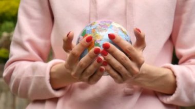 Kırmızı manikür ile kadın elleri üzerinde Ukrayna Kiril harfleri geografical isimleri ile küçük bir dünya veren. Ekolojik problemler konsepti
