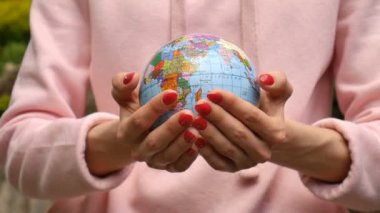 Üzerinde Ukrayna Kiril harfleri geografical isimleri ile küçük bir dünya veren kırmızı manikür ile kadın ellerin video yakın. Çevre dostu Galibi atletizm ayarlamak kavramı
