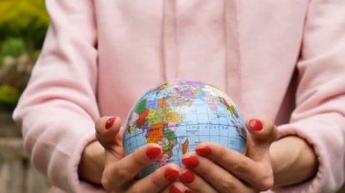 Üzerinde Ukrayna Kiril harfleri geografical isimleri ile küçük bir dünya veren kırmızı manikür ile kadın ellerin video yakın. Çevre dostu Galibi atletizm ayarlamak kavramı