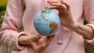 Kırmızı manikür ile pembe rahat kıyafetler genç kadın ergen elinde Ukraynalı Kiril harfleri geografical isimleri ile küçük bir dünya tutarak. Çevre sorumluluğu konsepti.