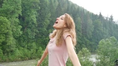 Güzel mutlu kız ormanlarla kaplı dağların fon karşı yaz yağmurayakta. Genç kadın mutlu whirls ve sıcak yaz yağmursahiptir