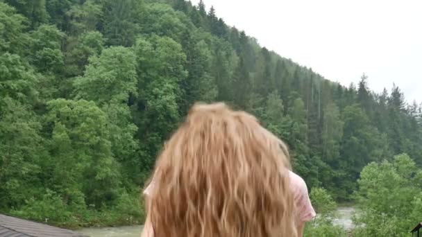 Chica rizada feliz en las montañas disfruta de la lluvia de verano sin un paraguas. La chica es feliz y se ríe alegremente. belleza de la naturaleza — Vídeo de stock