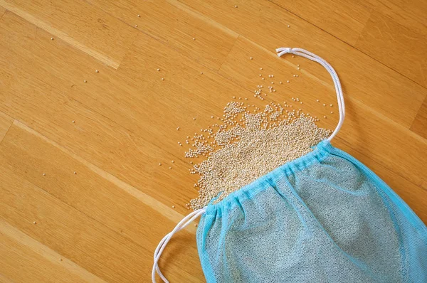 Sementes de quinoa branca em pacote reutilizável azul em fundo de madeira. Espaço de cópia — Fotografia de Stock