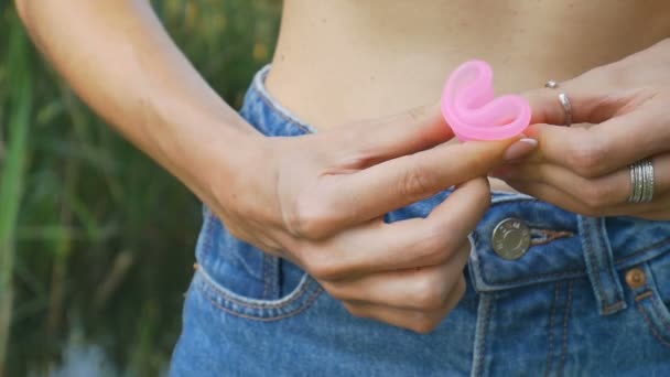 Close up de mãos de mulher segurando copo menstrual. Saúde das mulheres e conceito de resíduo zero — Vídeo de Stock