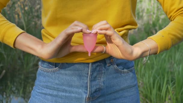 Gros plan des mains de la femme tenant la coupe menstruelle. Santé des femmes et concept zéro déchet — Video