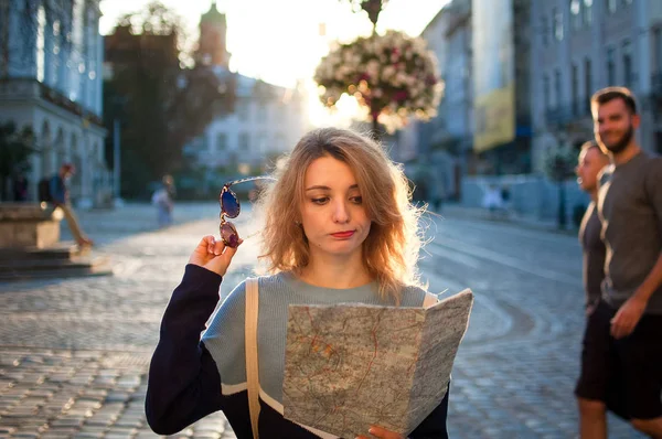 Mulher é perdida na velha cidade europeia olhando para um mapa e procurando direção no início da manhã na praça antiga vazia — Fotografia de Stock