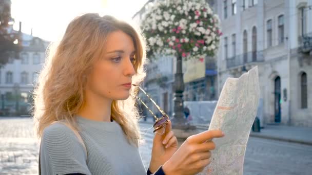 Vrouw gaat verloren in de oude Europese stad kijken naar een kaart en op zoek naar richting vroeg in de ochtend op lege oude plein. — Stockvideo