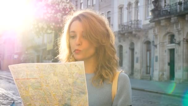 La mujer se pierde en la vieja ciudad europea mirando un mapa y buscando la dirección temprano en la mañana en la plaza antigua vacía . — Vídeos de Stock