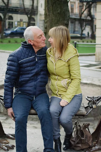 Hombre mayor guapo está abrazando a su joven esposa rubia pasar tiempo juntos al aire libre en la ciudad antigua durante principios de primavera u otoño . —  Fotos de Stock