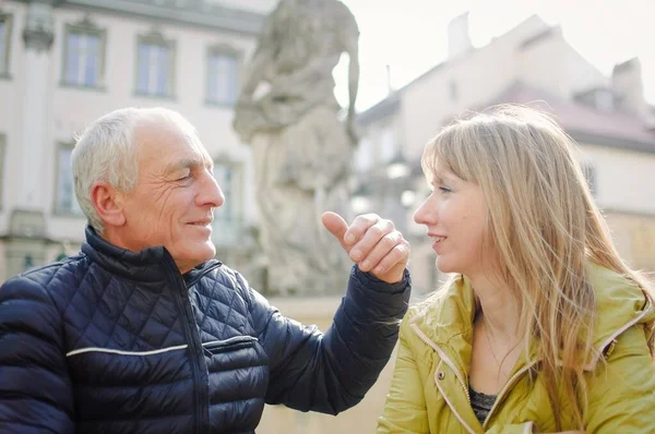 Красивый пожилой мужчина обнимает свою молодую блондинку жену, проводя время вместе на свежем воздухе в древнем городе ранней весной или осенью. . — стоковое фото