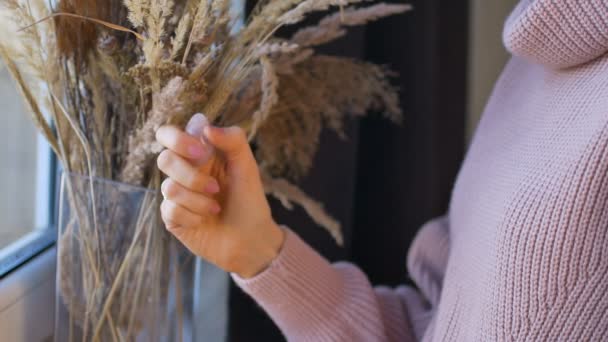 Mujeres mano sosteniendo yoni huevo hecho de piedra de cuarzo rosa sobre el fondo de espiguillas. Concepto de salud femenina, vumfit, imbuilding o meditación — Vídeo de stock