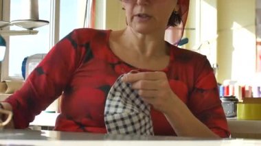 Olgun kadın ev yapımı nefes maskesi yapıyor, Corona virüsü koruması. Ev yapımı tıbbi maske. Kişisel koruyucu ekipman konsepti.