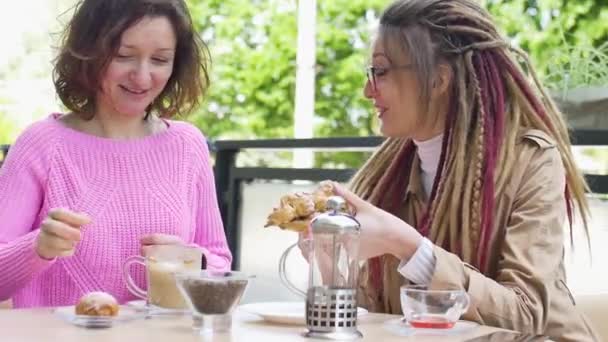 Deux jeunes amies déjeunent ensemble dans un café à l'extérieur pendant une journée au printemps — Video