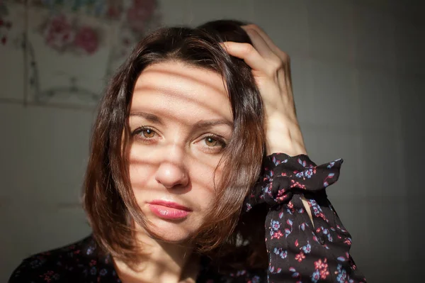 Feminino dentro de casa retrato de jovem morena com maquiagem e lábios sensuais em casa em azulejos brancos fundo na cozinha — Fotografia de Stock