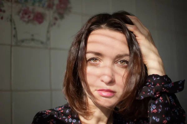 Feminino dentro de casa retrato de jovem morena com maquiagem e lábios sensuais em casa em azulejos brancos fundo na cozinha — Fotografia de Stock