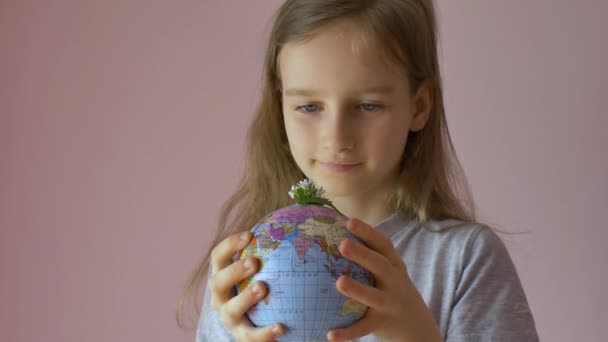 Earth globe with geographical names in Ukrainian cyrillic letters in hand of little blond girl. Human responsibility, world in hands, environmentally friendly concepts — Stock Video