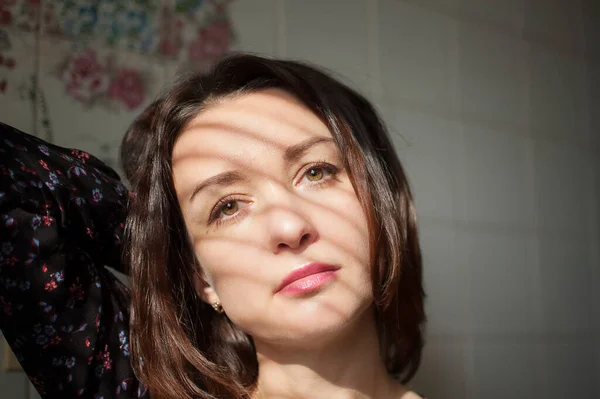 Feminino dentro de casa retrato de jovem morena com maquiagem e lábios sensuais em casa em azulejos brancos fundo na cozinha — Fotografia de Stock