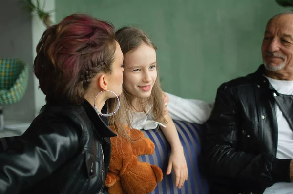 Retrato familiar de hija adulta, nieta pequeña y abuelo mayor en habitación loft con plantas de interior. Hombre y mujer están usando chaquetas de cuero negro en estilo punk, concepto de generación — Foto de Stock