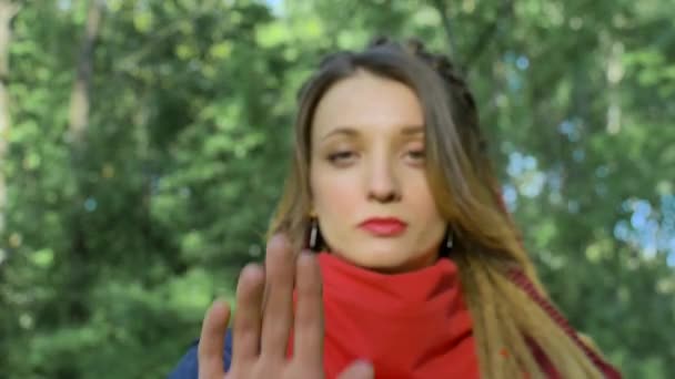 Modern serious girl with long dreadlocks in red scarf is showing hands with written slogan You cant restrict our rights on green tree background. Responsibility, protests concepts — Stock Video