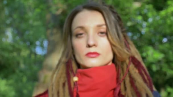 Modern serious girl with long dreadlocks is showing hands with written slogan Stop vaccine on green tree background. Responsibility, healthy living, protests concepts — Stock Video