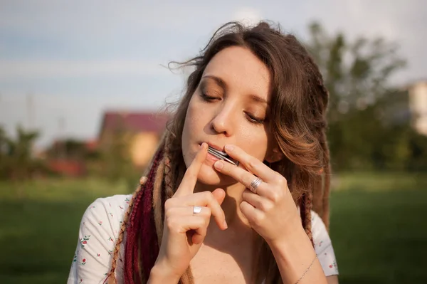 Nahaufnahme im Freien Porträt einer jungen Schamanin mit langen Dreadlocks, die auf traditioneller Hutsul-Drymba, Maultrommel, silbernem Vargan spielt — Stockfoto