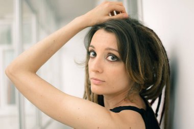 Kapalı alanda uzun saçlı, siyah gözlü, şehvetli bir kızın portresi. Farklı ol, alternatif insan kavramları.