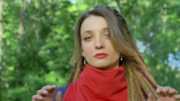 Moderna ragazza seria con lunghi dreadlocks in sciarpa rossa sta mostrando le mani con slogan scritto Non è possibile limitare i nostri diritti su sfondo albero verde. Responsabilità, concetti di protesta — Video Stock