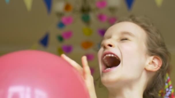 Urodziny dzieci. Mały śmiech cute girl jest świętowanie jej b-day z kolorowych balonów na papierowym tle girlandy w domu — Wideo stockowe