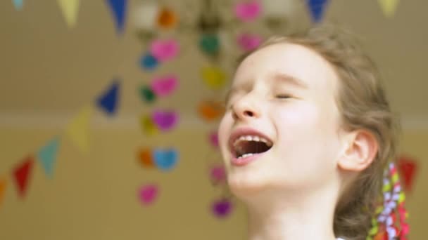 Kinderen verjaardagsfeestje. Klein lachen schattig meisje is het vieren van haar b-dag met de kleurrijke ballonnen op papier slinger achtergrond thuis — Stockvideo