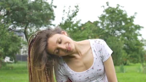 Draußen weibliches Porträt eines modernen Mädchens mit Dreadlocks im weißen Hemd in einem Stadtpark bei Sonnenuntergang, frei sein, sich selbst sein Konzept — Stockvideo