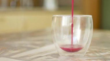 Masadaki çifte cam bardakta taze süt ve ejderha meyvesi tozundan yapılmış pembe kibrit latte.