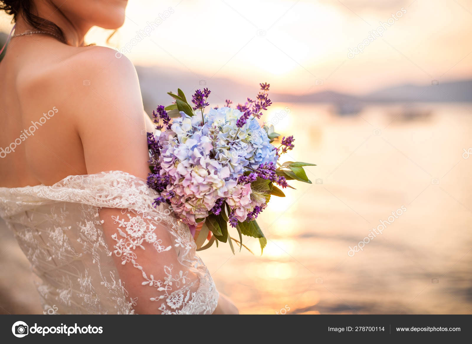 Cerimônia de casamento na praia do oceano. A noiva mantém o buquê de  casamento de hortênsias