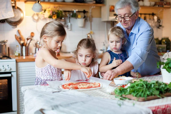 Children chefs are cooking italian pizza in cozy home kitchen for family dinner.