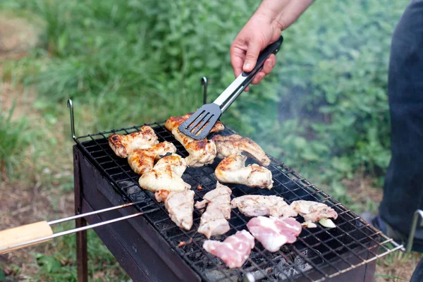 Man is cooking barbecue. Picnic with grilled meat. Bbq party in summer backyard.
