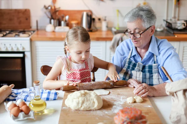 Family cooking at home. Grandmother and child making italian food and meal in cozy kitchen.