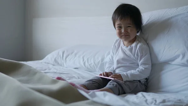 Små Asiatiska Kinesiska Småbarn Sitter Sängen Med Ipad Och Ler — Stockfoto