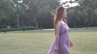 Asyalı Çinli kadın yavaş çim çimenlerin üzerinde yürüyüş