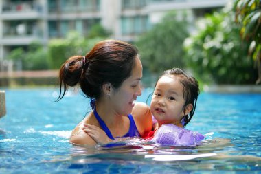 Mutlu gülümseyerek yüzme havuzunda Asya Çin anne ve kızı bağ