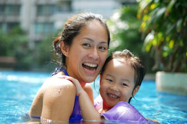 Mutlu gülümseyerek yüzme havuzunda Asya Çin anne ve kızı bağ