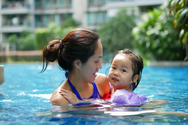 Mutlu gülümseyerek yüzme havuzunda Asya Çin anne ve kızı bağ