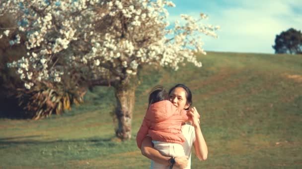 Asiatisk Kinesisk Kvinna Bär Sitt Barn Öppen Trädgård Med Sakura — Stockvideo