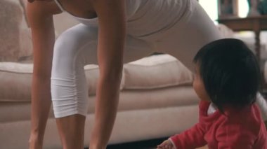 Beyaz Asyalı Çinli kadın küçük yürümeye başlayan bebek ile kapalı yoga pratik 