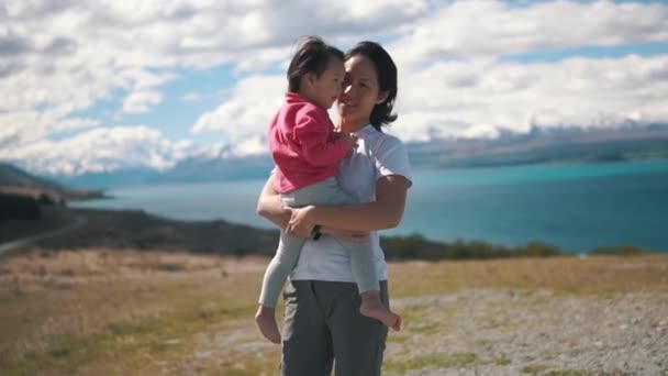 Ασίας Κινεζική Μητέρα Που Μεταφέρουν Παιδί Φόντο Μια Γαλάζια Λίμνη — Αρχείο Βίντεο