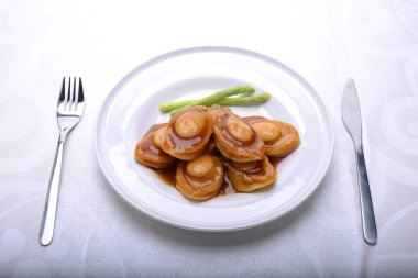 wide spread of abalone servings in a fine dining setting clipart