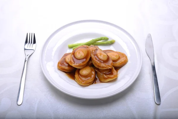 Wide spread of abalone servings in a fine dining setting — 스톡 사진