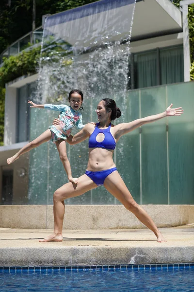 Čínská Asijská žena a dítě dělají z bazénu akrobatskou zábavu — Stock fotografie